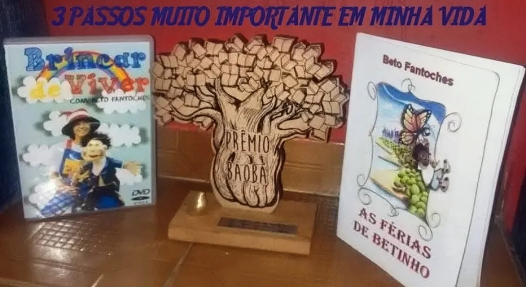 Um DVD, um troféu e um livro lado a lado, sobre a trajetória do Beto