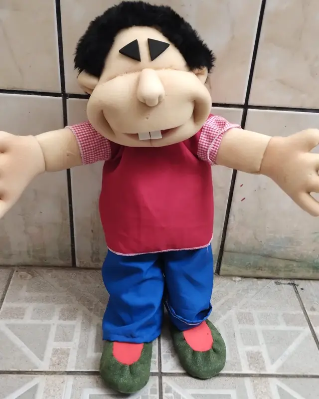 Menino de cabelo preto, camisa vermelha e calça azul