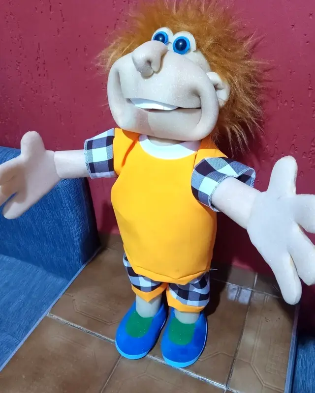 Samprinhas, fantoche de cabelo laranja arrepiado, colete laranja e bermuda xadrez